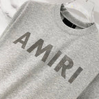 Amiri T-shirt in heather gray with large AMIRI logo across chest