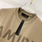 Olive T-shirt neckline close-up with AMIRI logo print and fabric texture