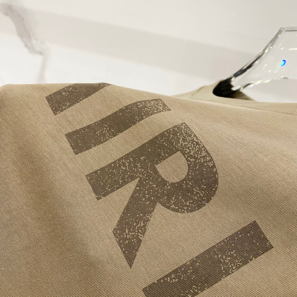 Olive T-shirt with large AMIRI logo print across the fabric