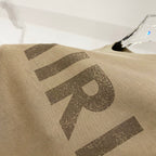 Olive T-shirt with large AMIRI logo print across the fabric