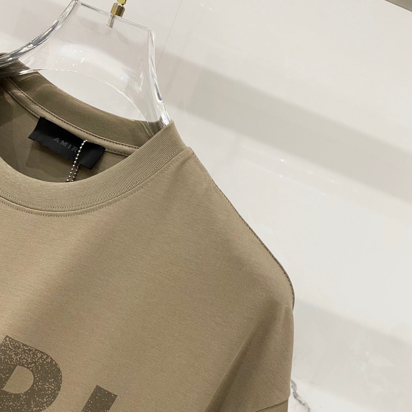 Olive T-shirt shoulder and sleeve seam close-up with crew neckline