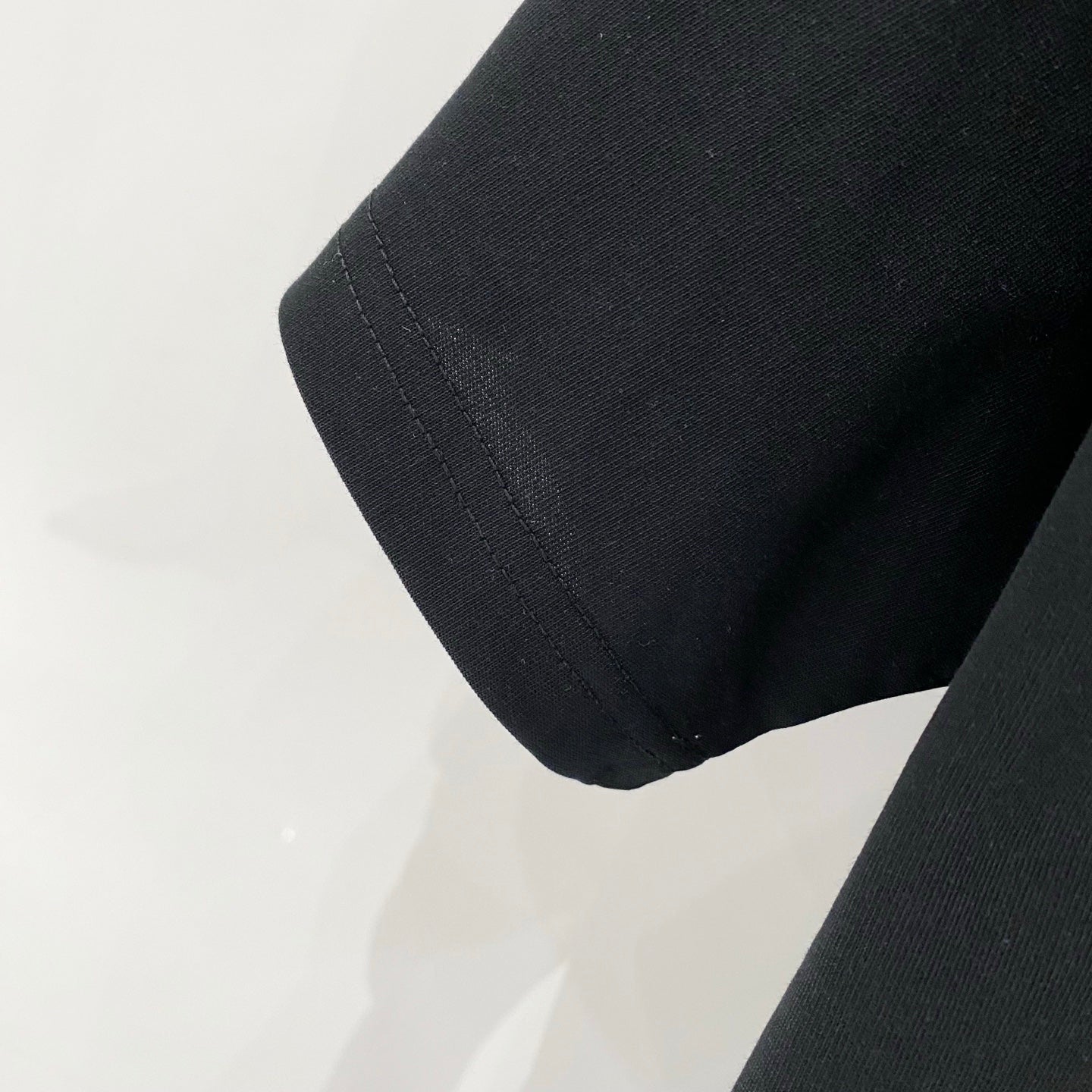 Black Amiri T-shirt sleeve cuff and hem stitching close-up