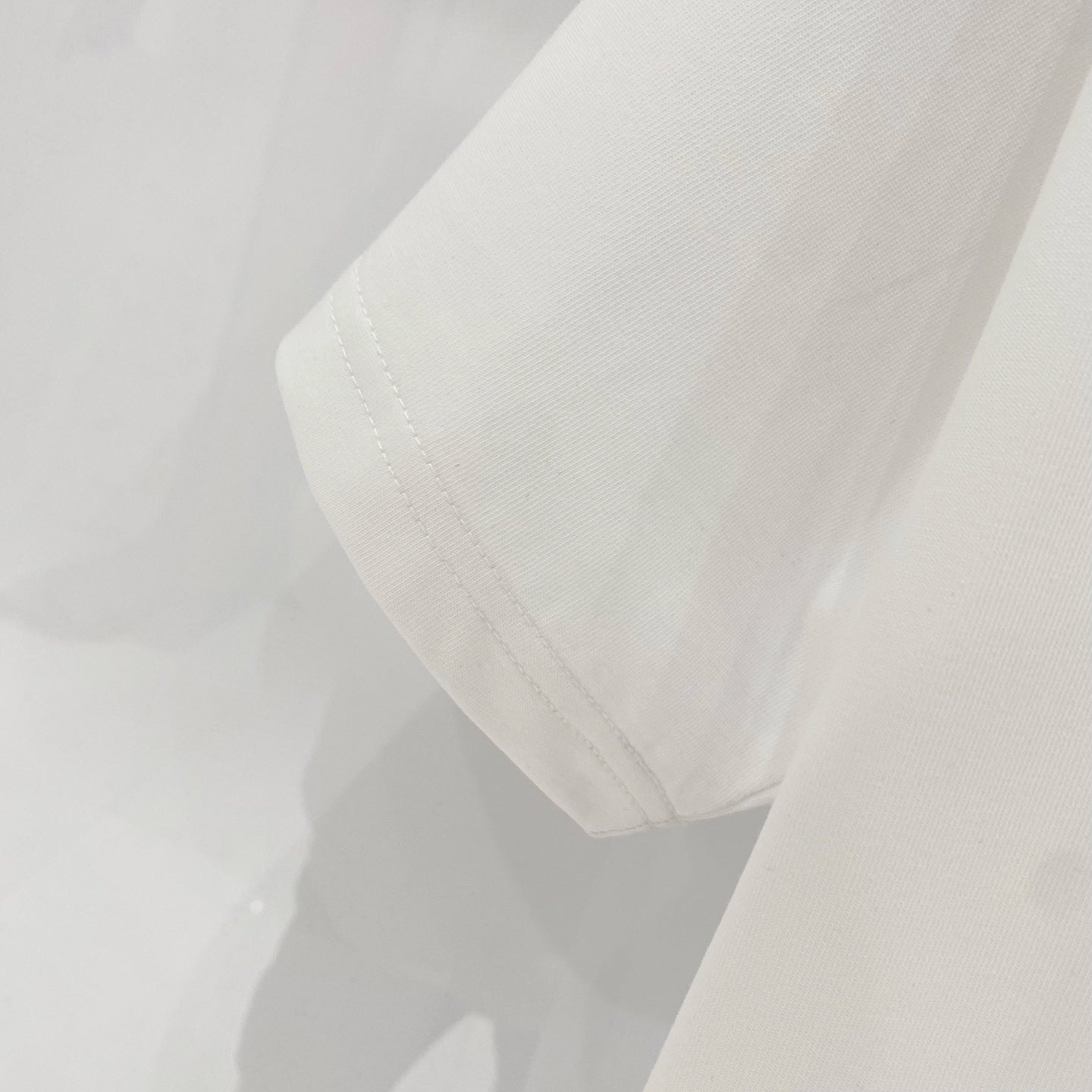 White T-shirt showing side seam and hem stitching detail.