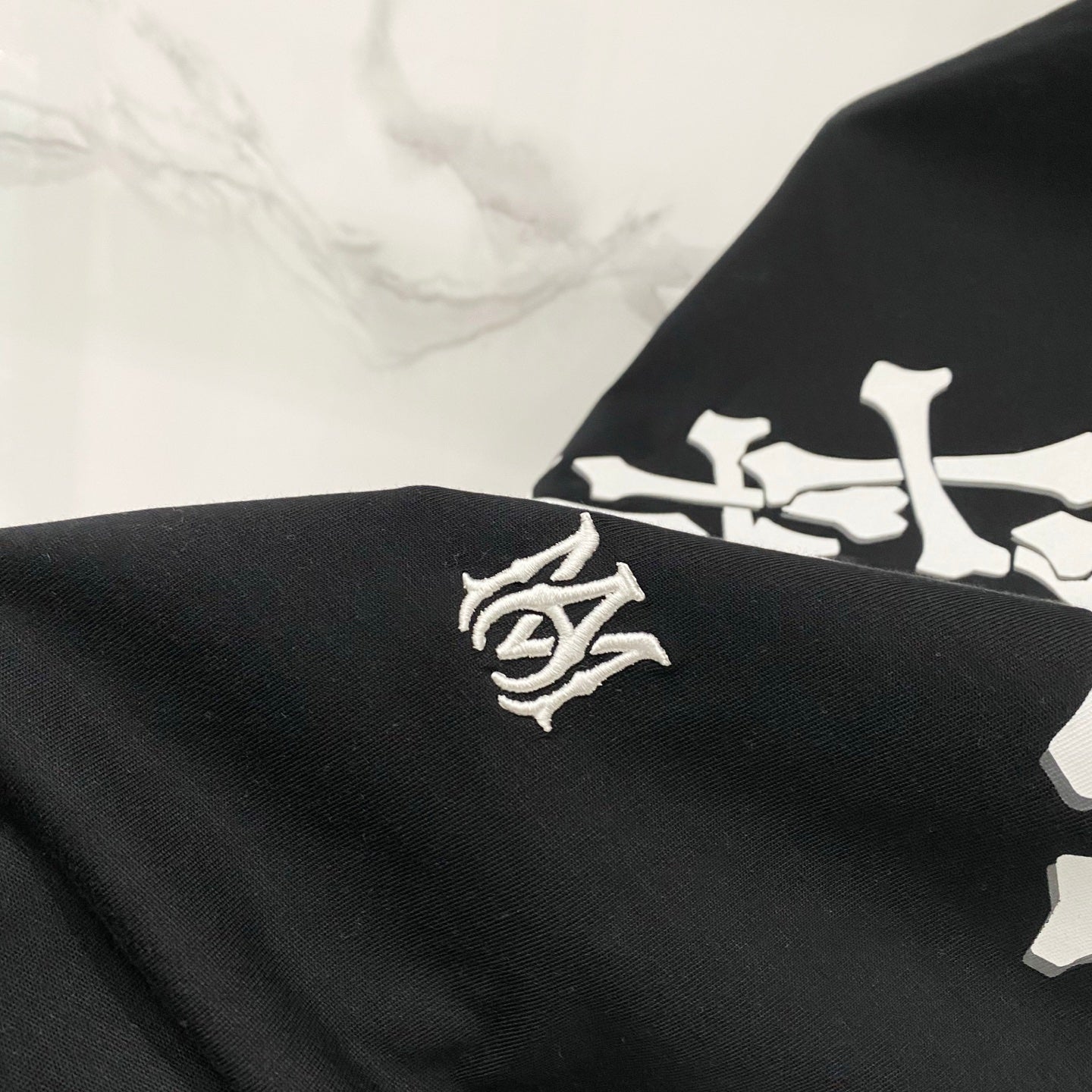 Black crewneck T-shirt with small white crest logo detail