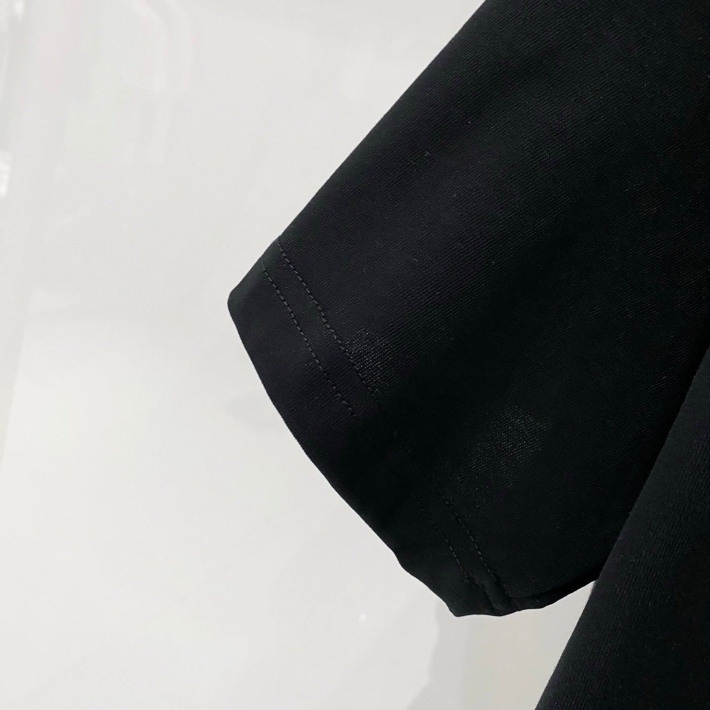 Black T-shirt sleeve hem with visible stitching