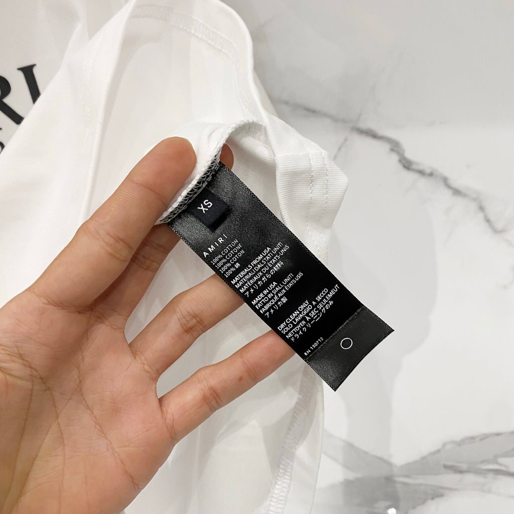 Amiri T-shirt care label and size tag attached at collar