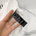 Amiri T-shirt care label and size tag attached at collar