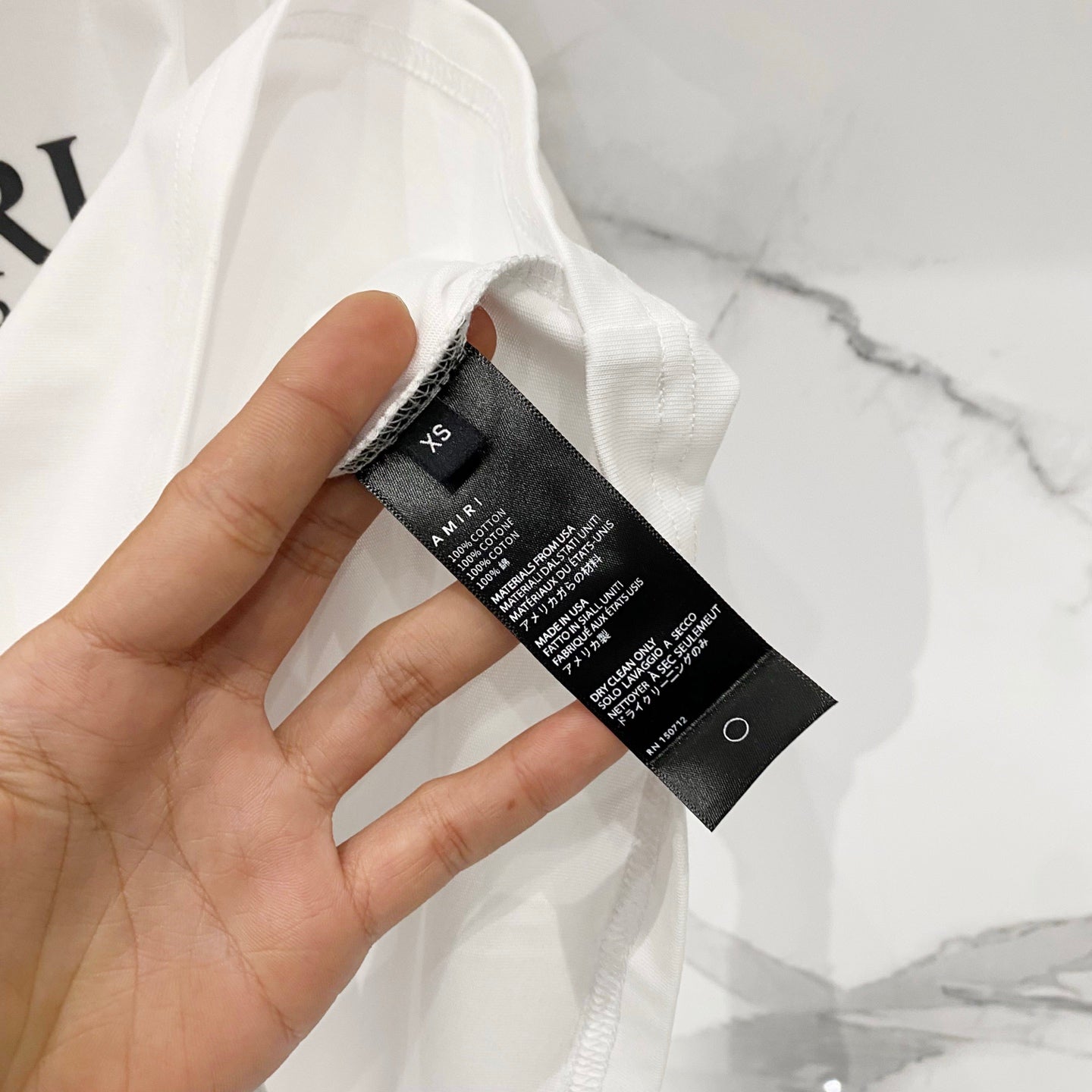 Amiri T-shirt care label and size tag attached at collar