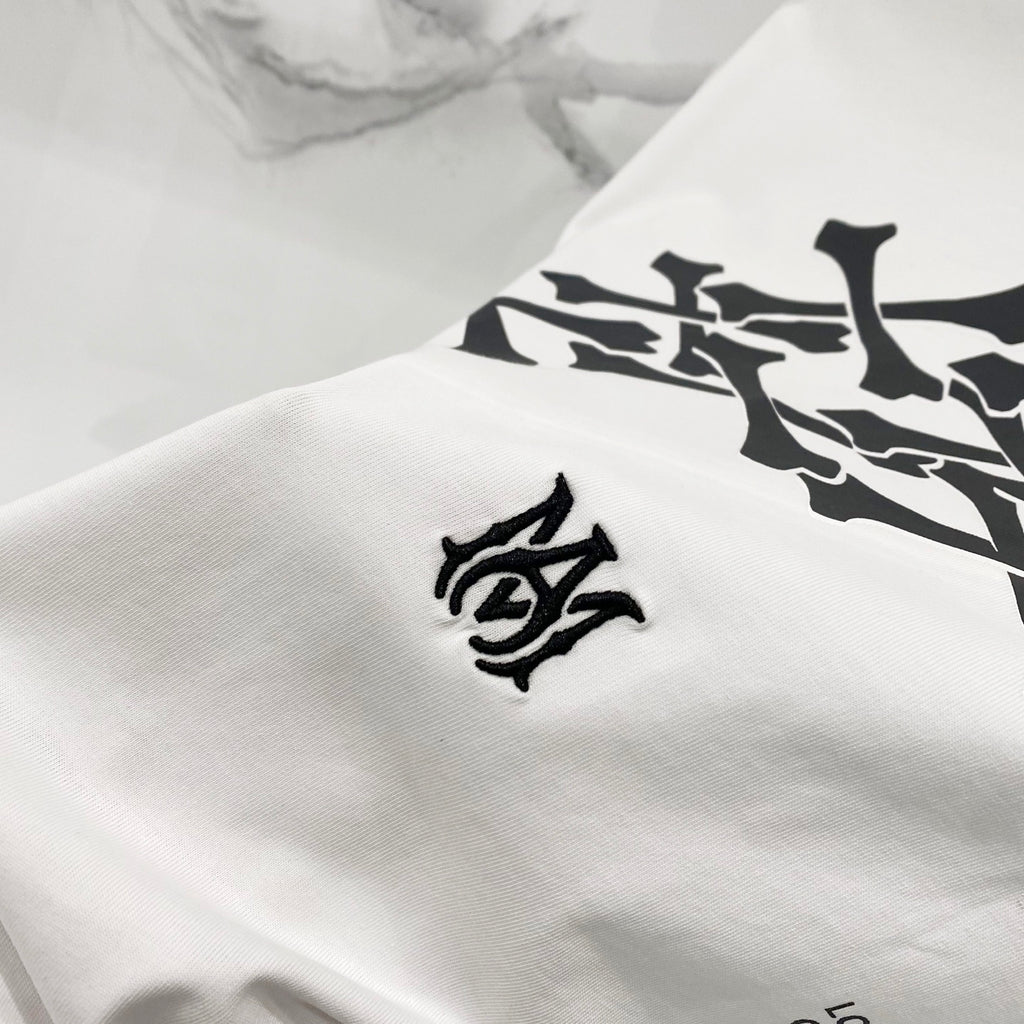 Amiri white T-shirt fabric close-up with small black logo emblem