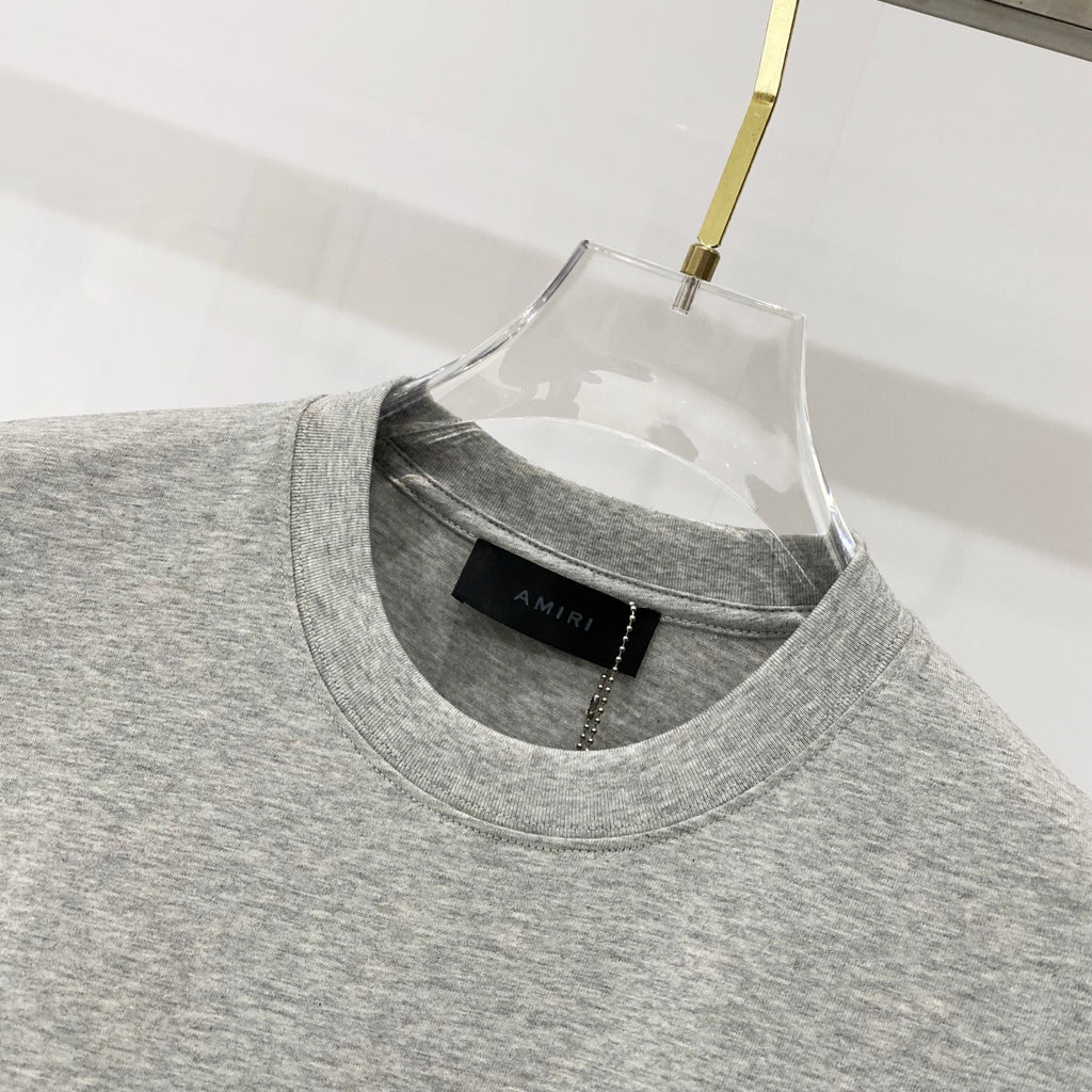 Heather gray Amiri T-shirt crew neck with black brand label at collar
