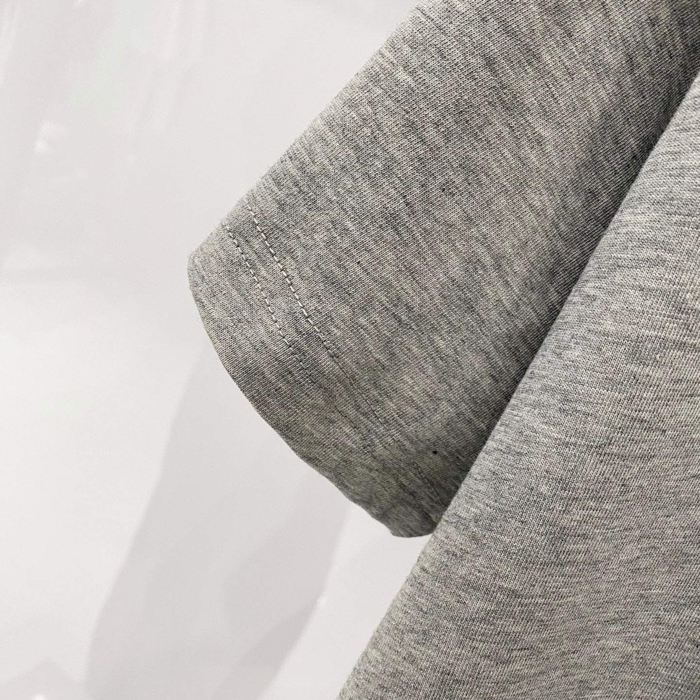Heather gray Amiri T-shirt sleeve close-up with stitched hem