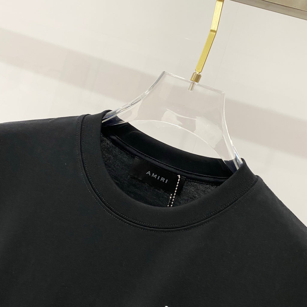 Black crewneck T-shirt with AMIRI logo label at neckline seam