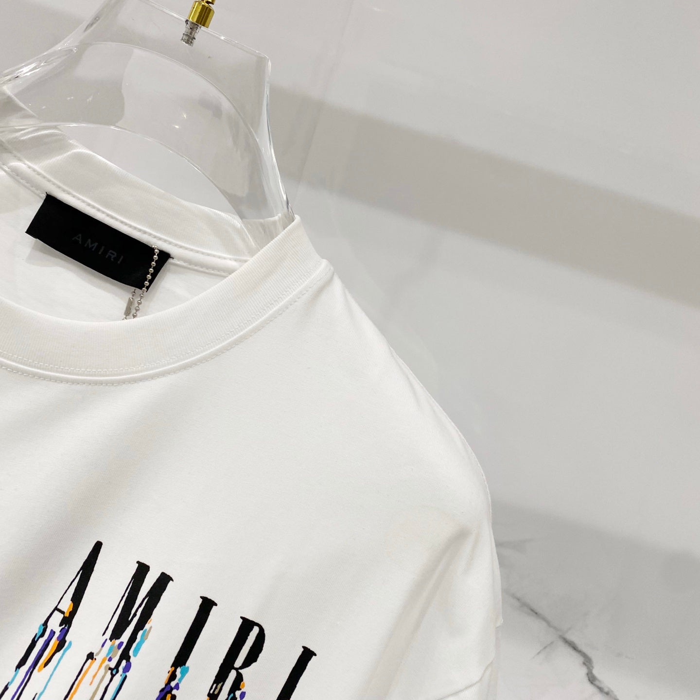 White crewneck T-shirt with AMIRI drip logo print and black neck label