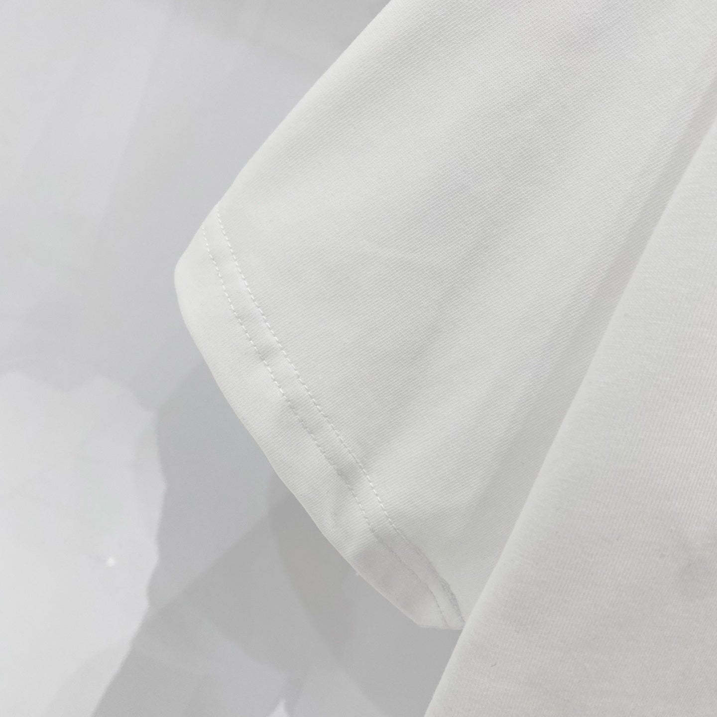 White T-shirt sleeve and side hem with visible stitching