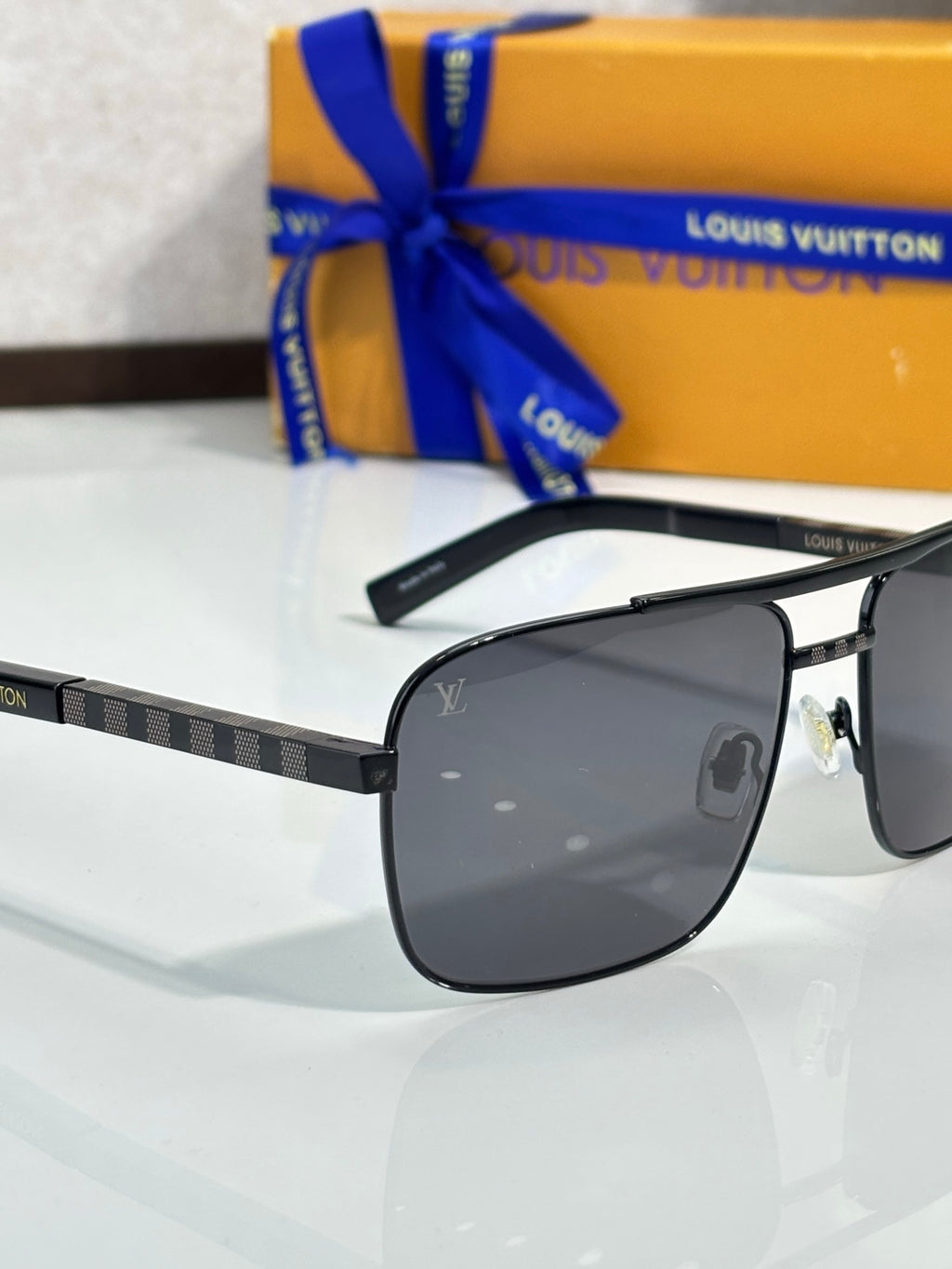 Louis Vuitton black sunglasses with dark lenses and patterned temple band