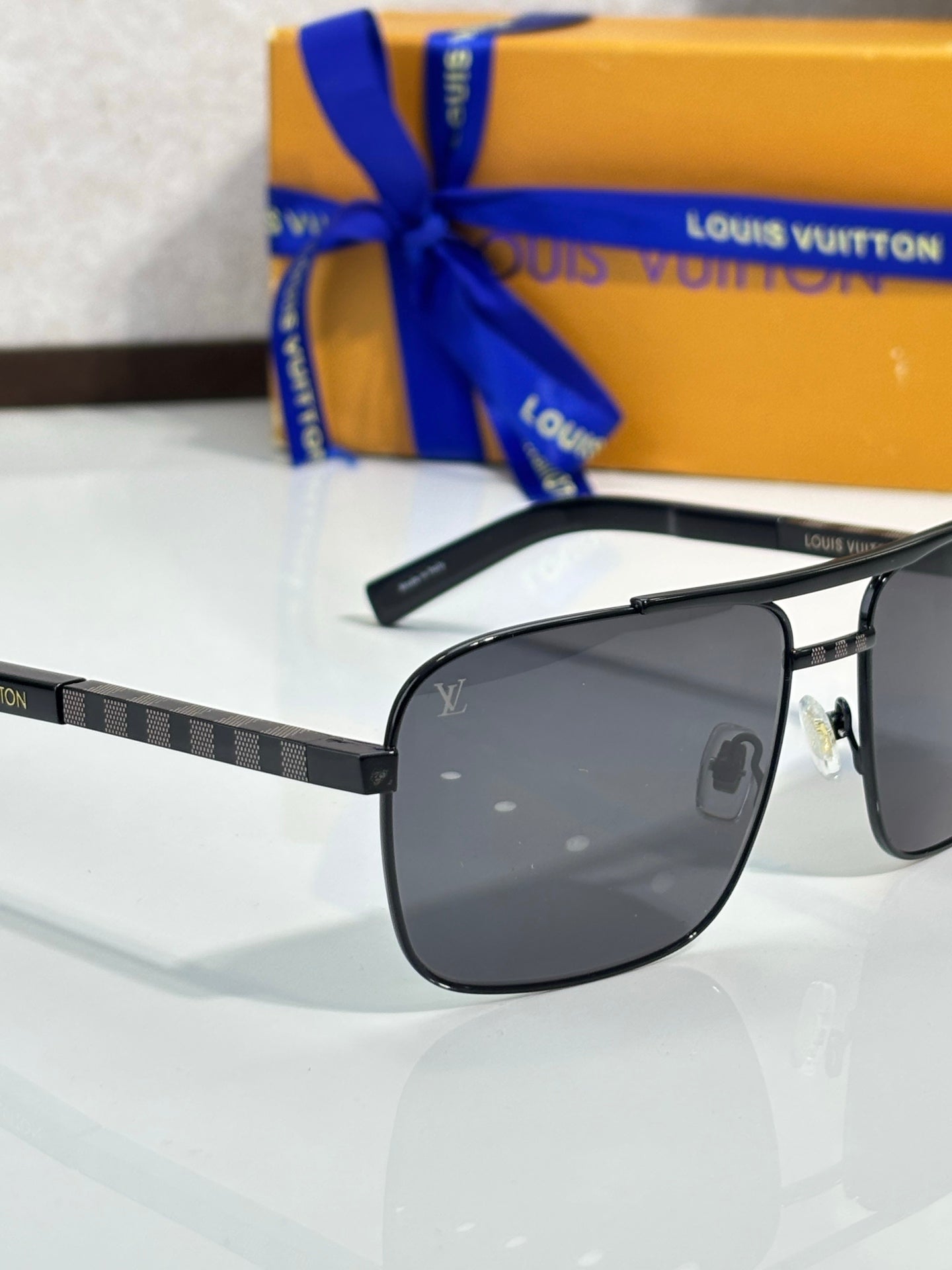 Louis Vuitton black sunglasses with dark lenses and patterned temple band