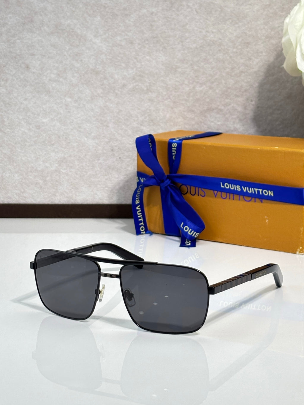 Louis Vuitton square sunglasses with black temples, silver frame, and dark lenses