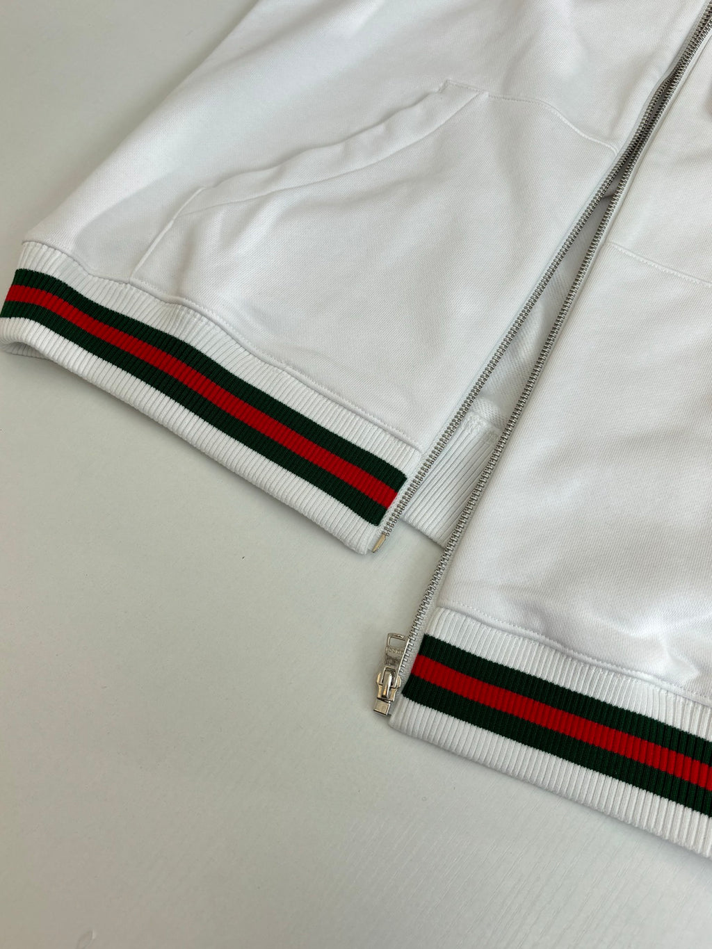 Gucci white zip hoodie with striped waistband near zipper