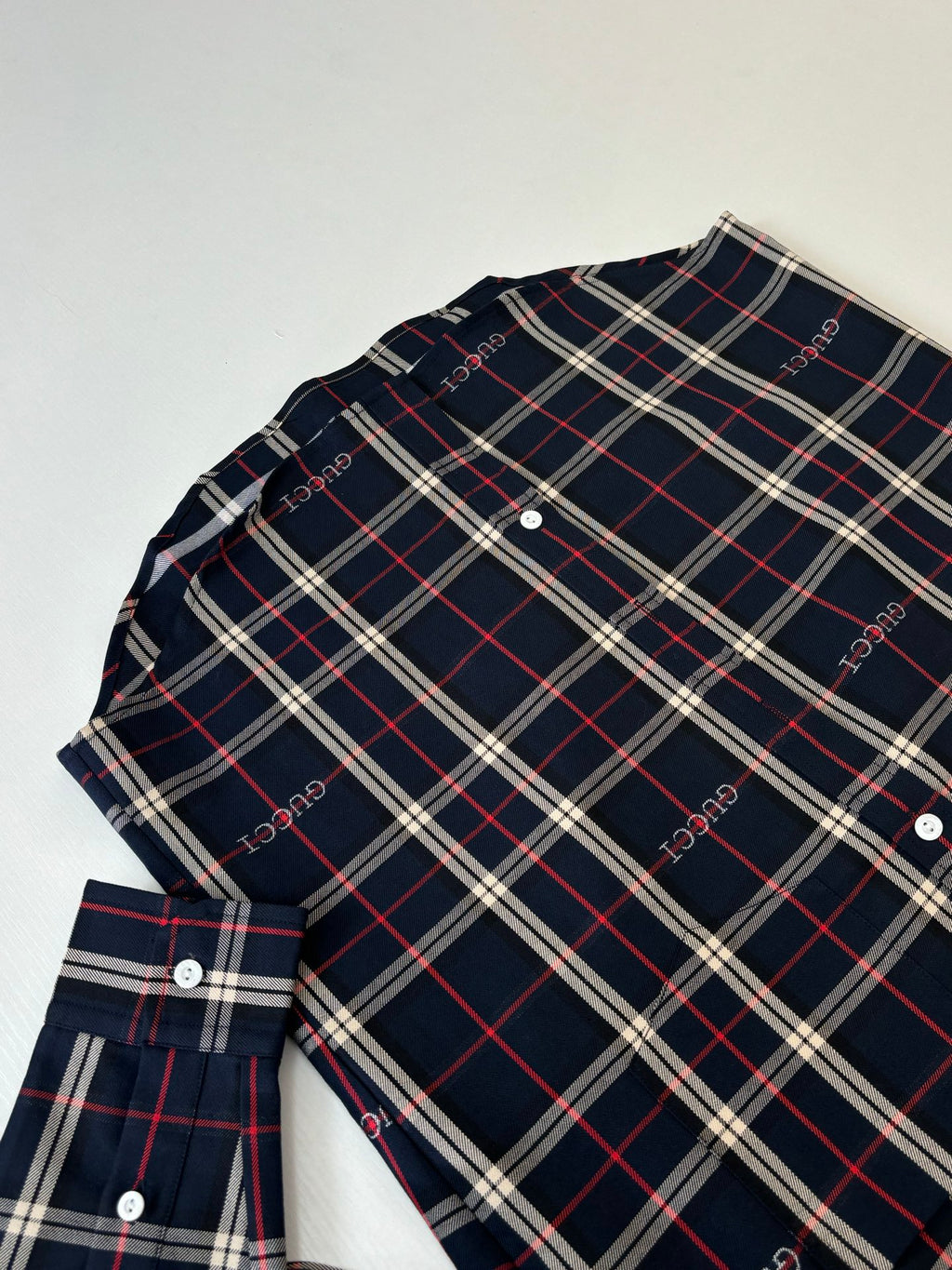 Gucci long-sleeve plaid shirt laid flat, dark navy with red and white grid pattern
