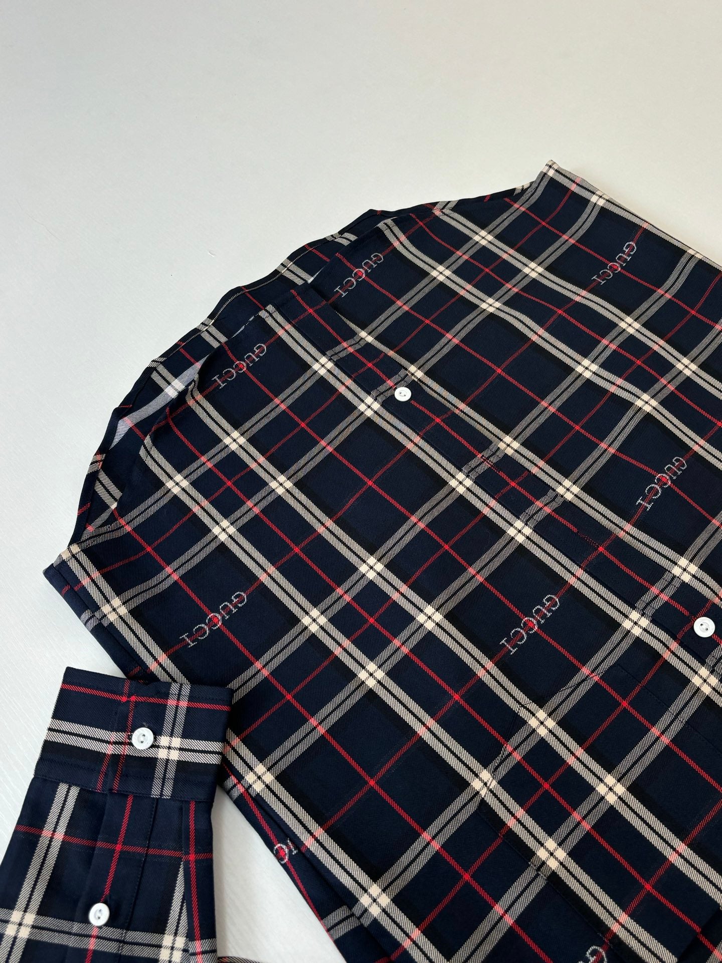 Gucci long-sleeve plaid shirt laid flat, dark navy with red and white grid pattern