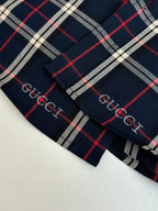 Gucci long-sleeve plaid cuff close-up, dark navy with red and white grid stripe