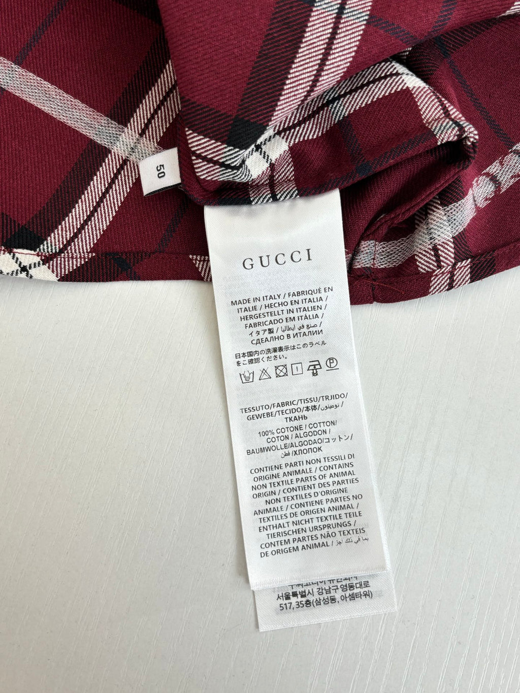 Red plaid long-sleeve shirt with white care label and collar