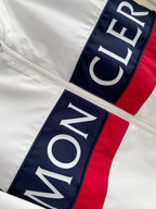 White long jacket with vertical MONCLER logo patch on navy/red trim