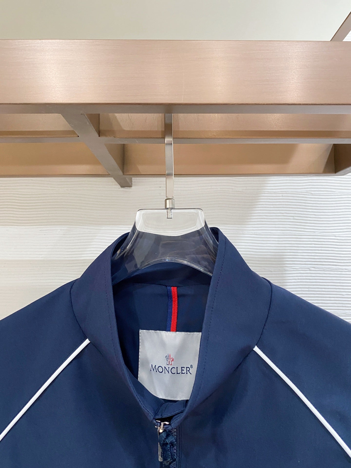 Dark navy zip jacket with stand collar and white inner logo label