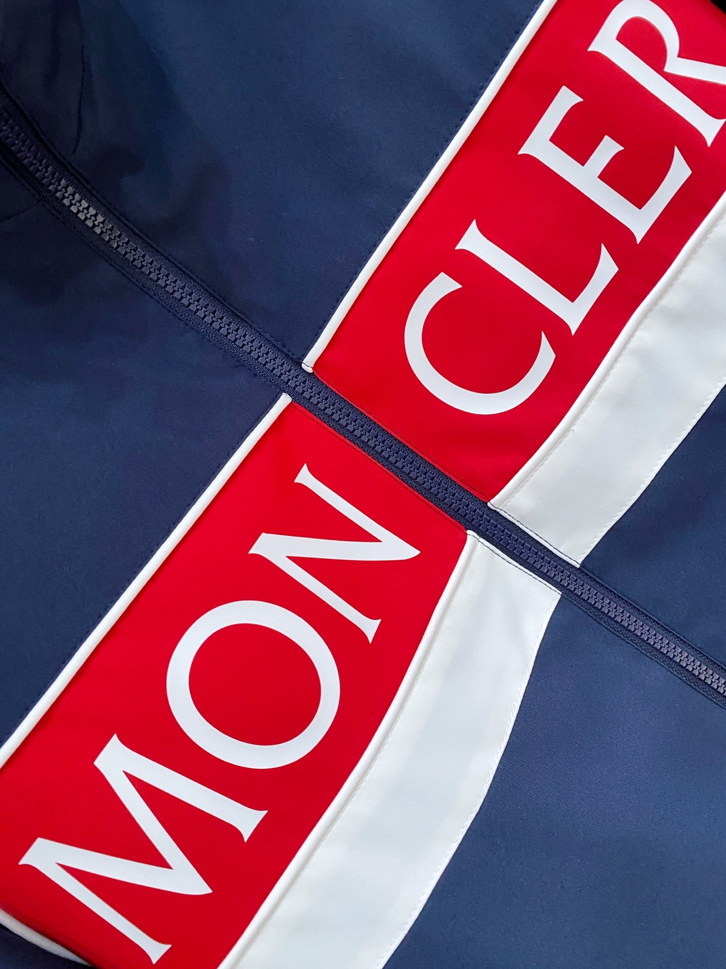 Red and white logo stripe on navy jacket