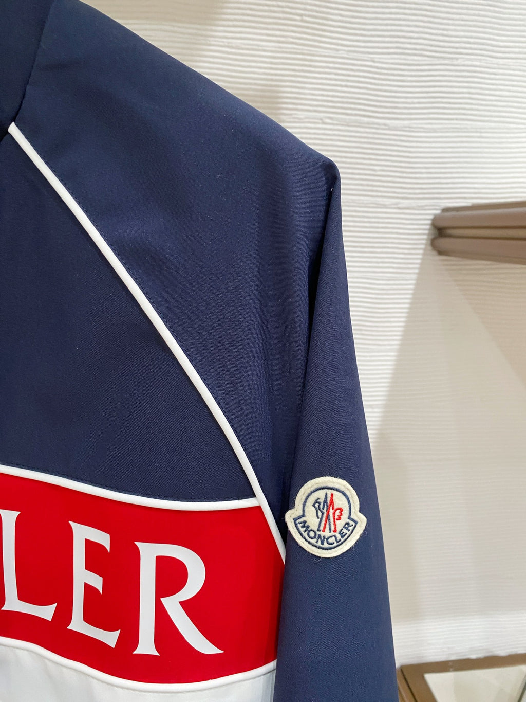 Logo stripe detail on navy jacket with crest patch