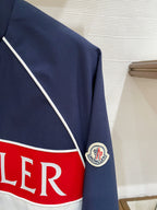 Logo stripe detail on navy jacket with crest patch