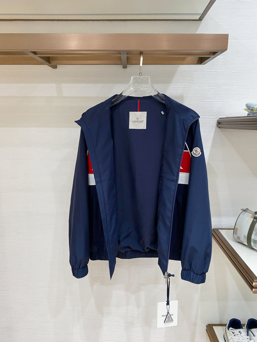 Back view of dark navy jacket with white piping and red/white side stripes