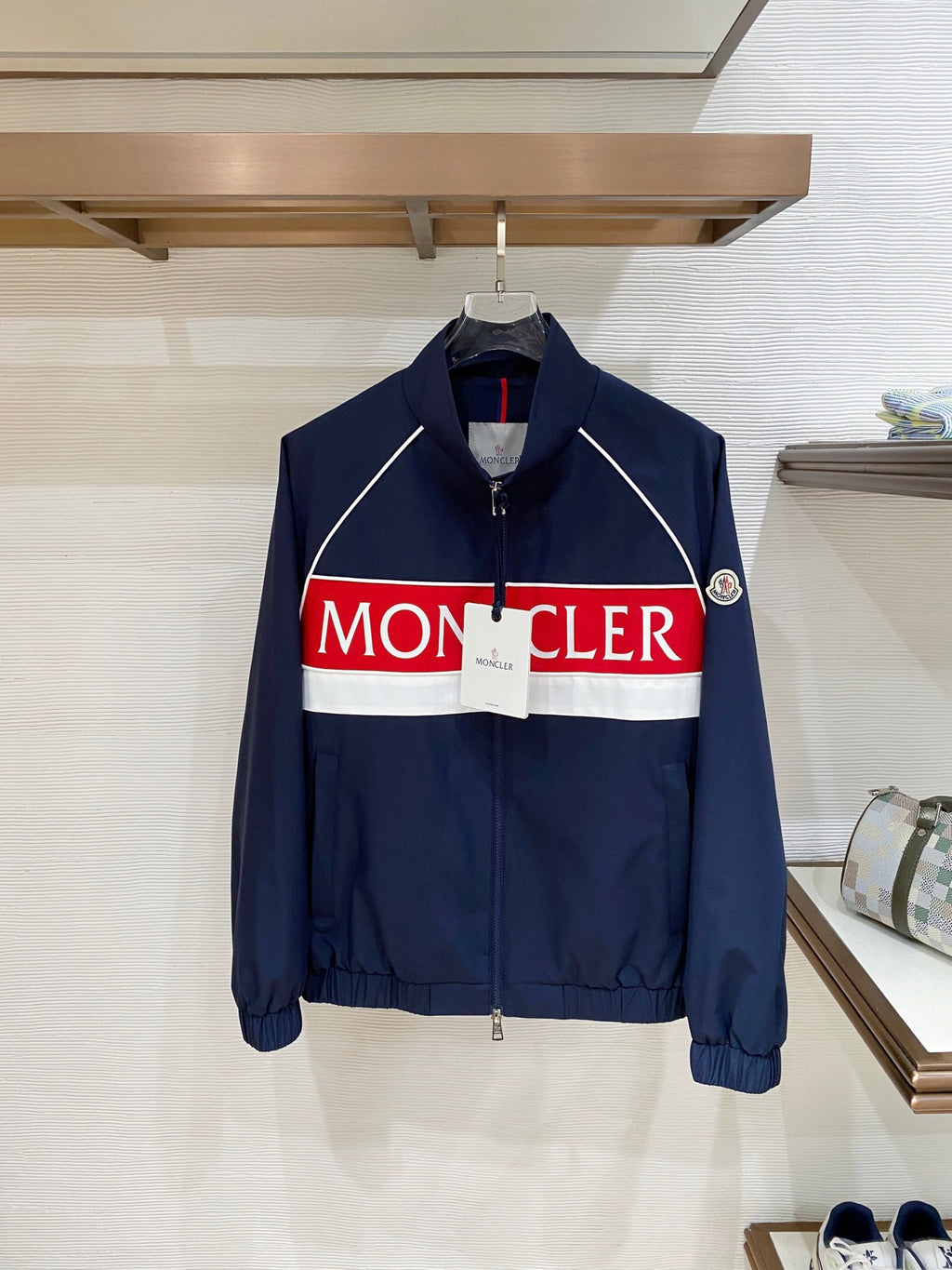 Navy zip-front jacket with white piping and red/white logo band