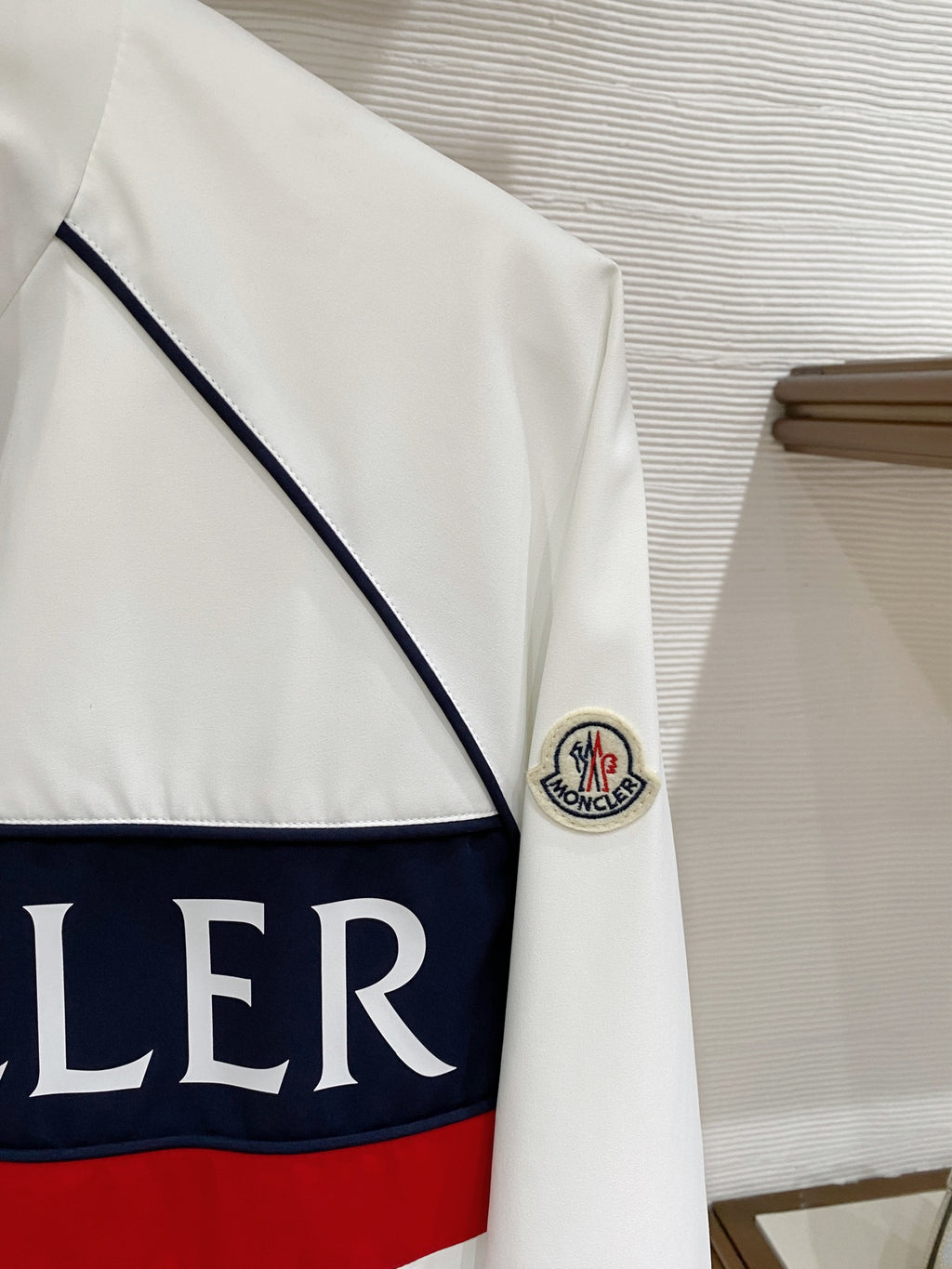 White long jacket front panel with navy band and red stripe