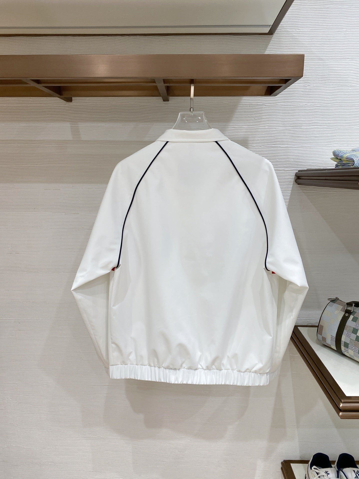 White long jacket back with navy-trim curved yoke and zipper hem