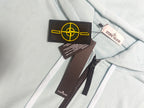 Stone Island light blue zip-up hoodie neckline with drawstrings and tags