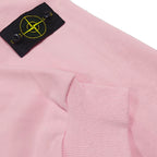 Pink hoodie sleeve cuff with black fabric patch and yellow Stone Island emblem