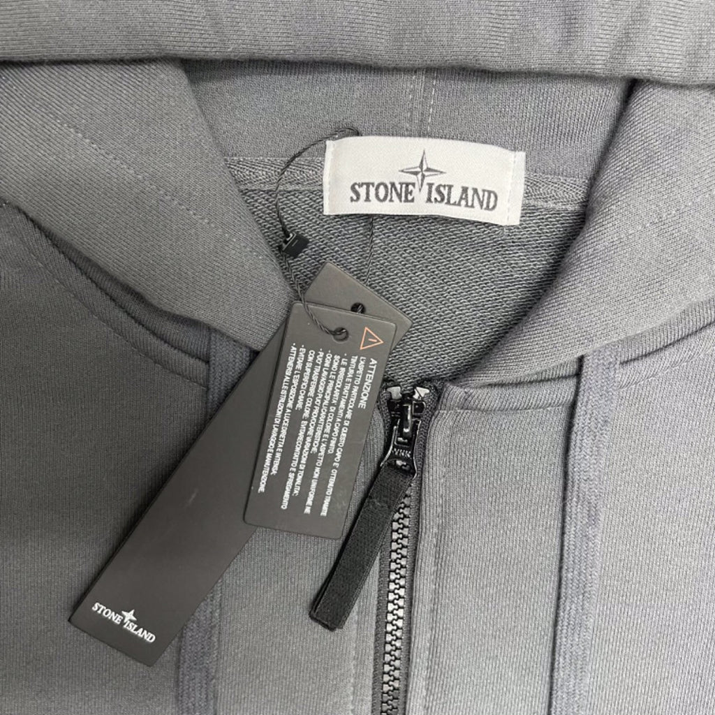 Stone Island hooded jacket neck close-up with zip, care labels, and drawstring