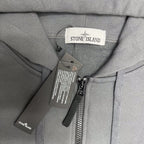 Stone Island hooded jacket neck close-up with zip, care labels, and drawstring