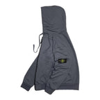 Dark gray hooded jacket with logo patch on sleeve and tied drawstrings