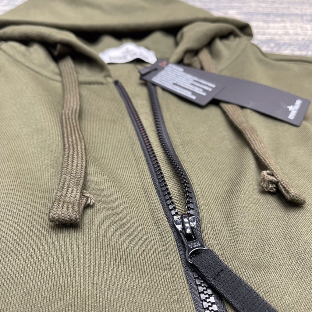 Olive zip-up hoodie detail with black zipper tape and drawcord ends