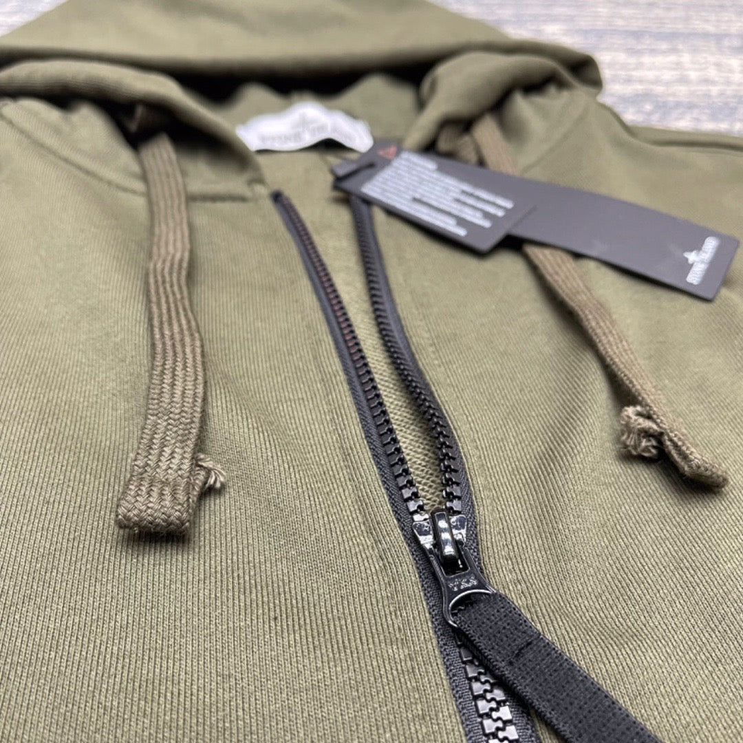 Olive zip-up hoodie detail with black zipper tape and drawcord ends