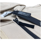 Stone Island light beige hoodie detail: dark zipper, fabric trim, and hang tag