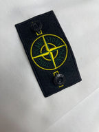 Black Stone Island logo patch with yellow compass graphic on white fabric