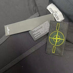 Dark hooded sweatshirt fabric close-up with branded hang tags