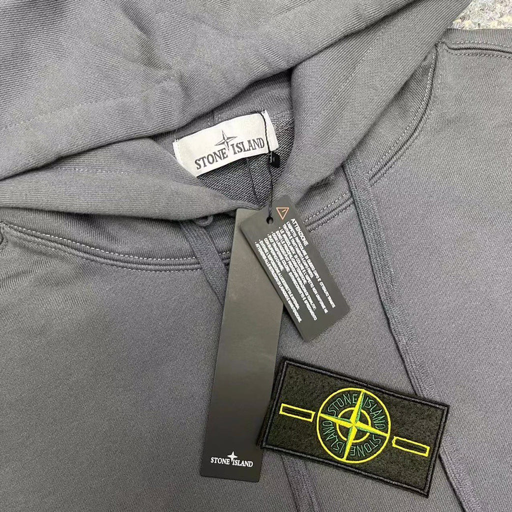 Gray hoodie with hood label and logo patch on chest