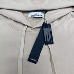 Cream hoodie hood with white drawstrings and Stone Island neck label, with tags