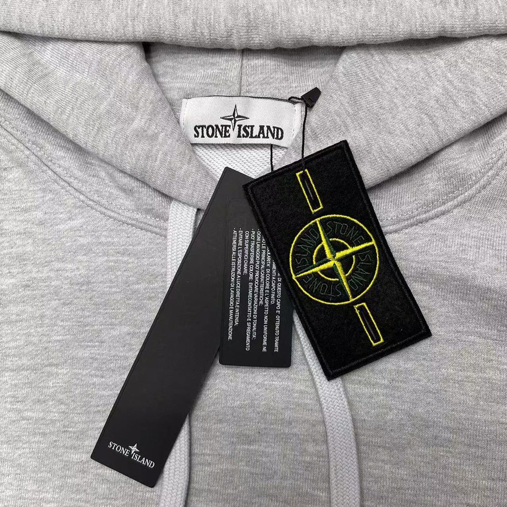 Stone Island gray hoodie close-up of yellow logo patch and drawstring