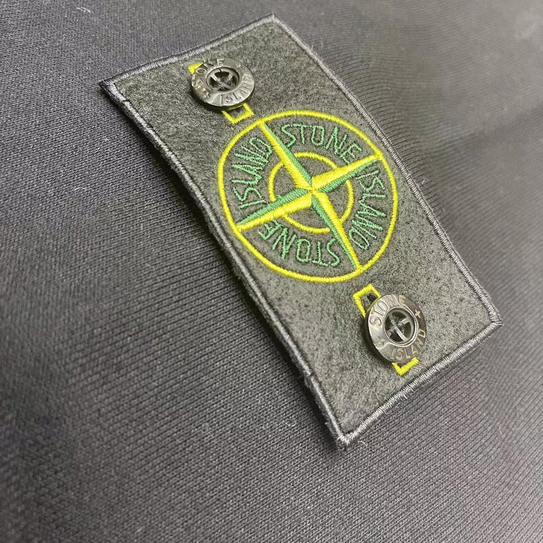 Gray hooded sweatshirt close-up of yellow logo patch on fabric