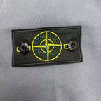 Stone Island embroidered logo patch in yellow on black fabric